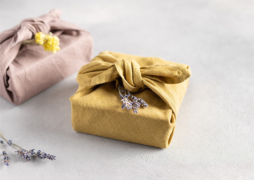 Two gifts wrapped in fabric using Furoshiki Japanese gift wrapping.