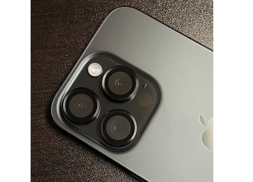 Photo of iPhone 15 rear camera lenses and black titanium finish.