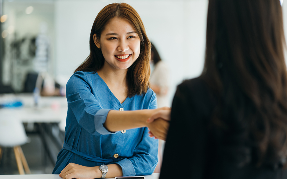 First-time jobseeker shakes a job interviewer's hand.