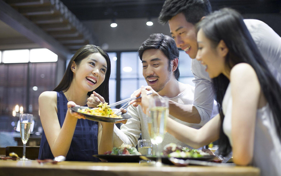 Group of young Asian friends enjoying dining in a trendy, new restaurant.