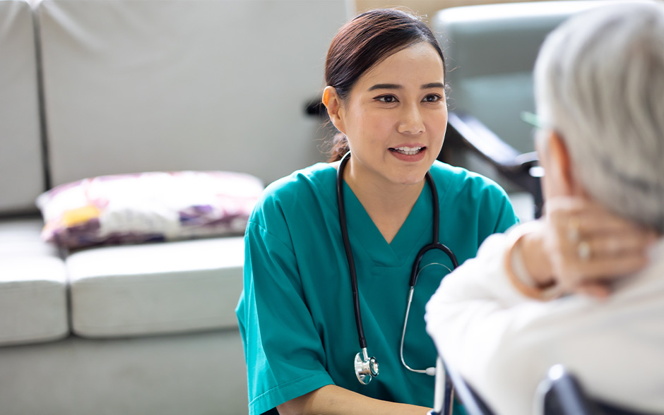 Asian female doctor talks to a senior patient.
