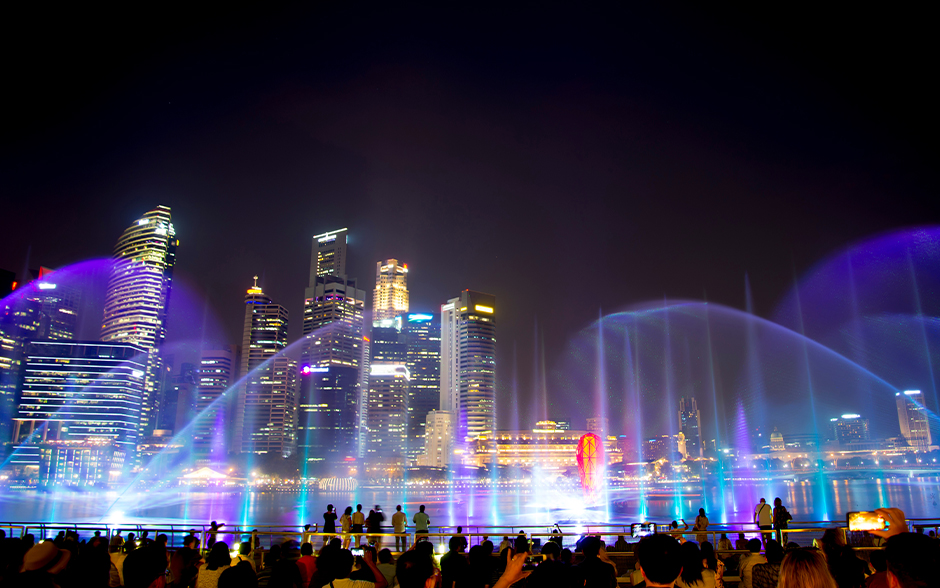 People watch Marina Bay Sands' light and water show.