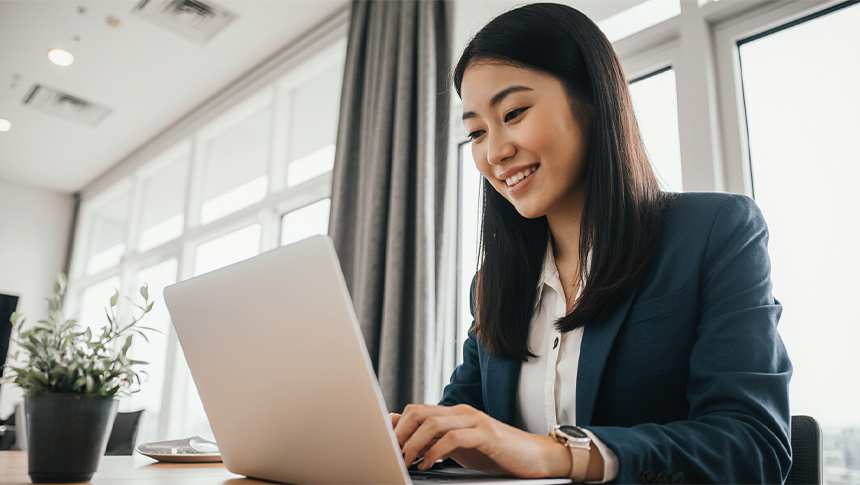 An Asian female professional using her laptop for work.