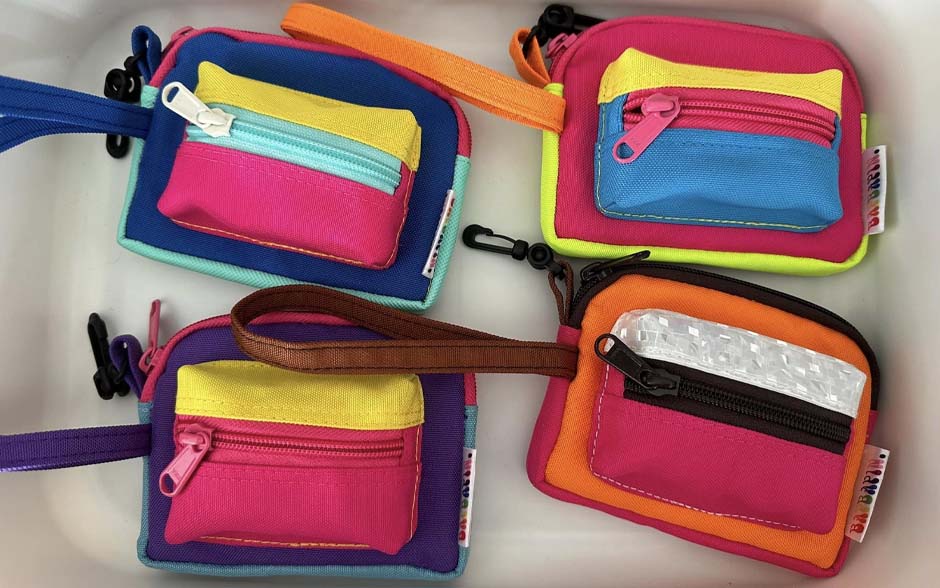 A set of colorful, upcycled coin purses with zippers and wrist straps.