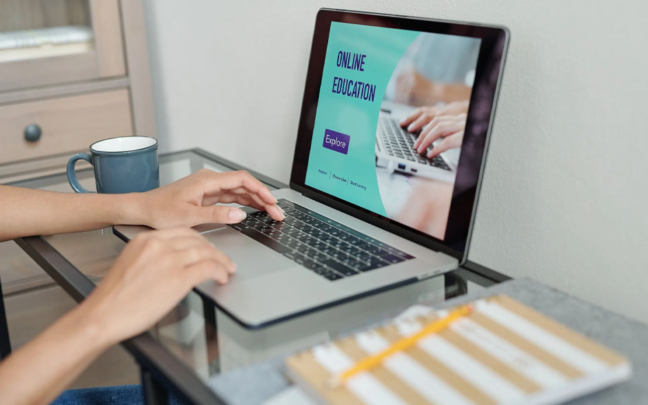 Cropped shot of hands typing on a laptop with the screen showing online education.