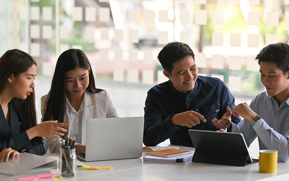 Young Filipino professionals brainstorming together at the office.