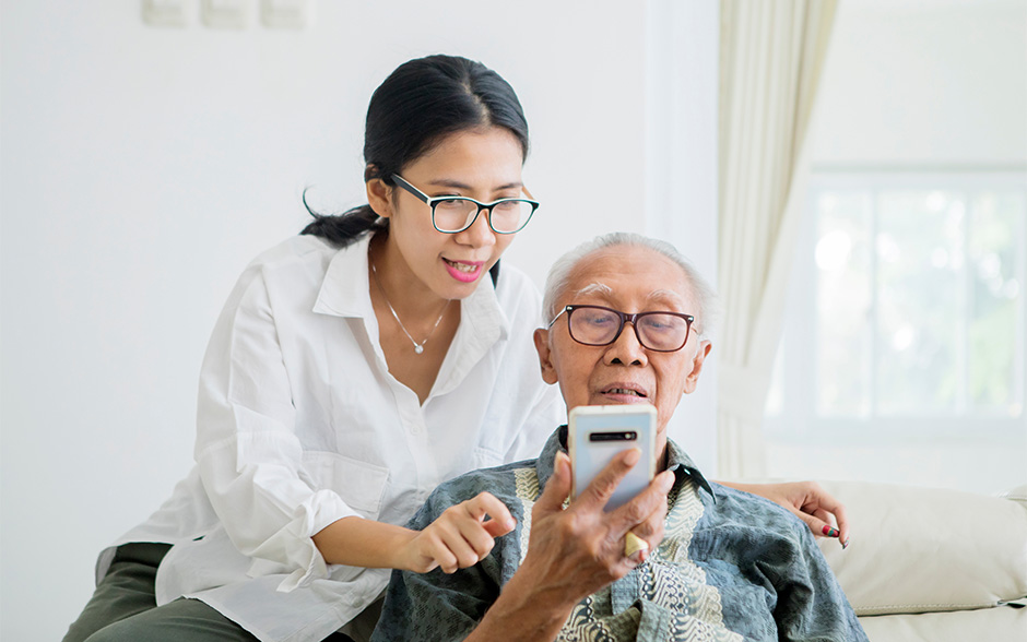 Daughter is helping her father with the phone