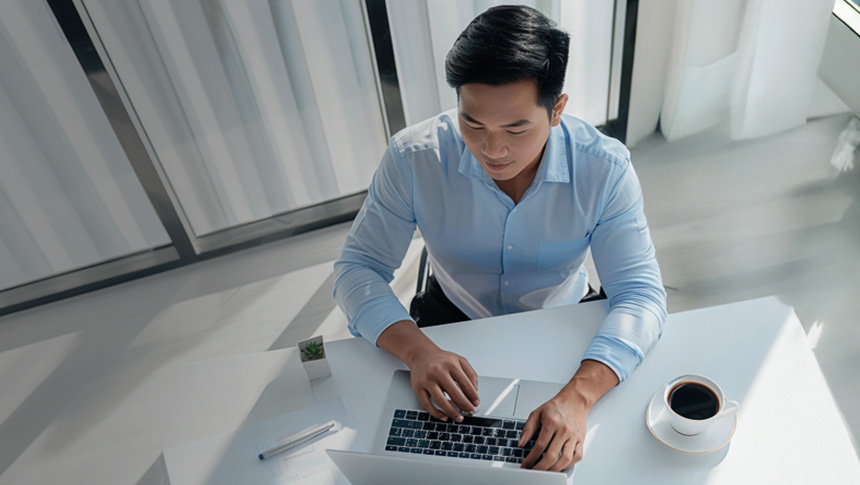 A man using a laptop in an office.