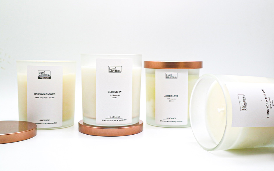 Four locally made Lumi candles, some with their lids on and others without.