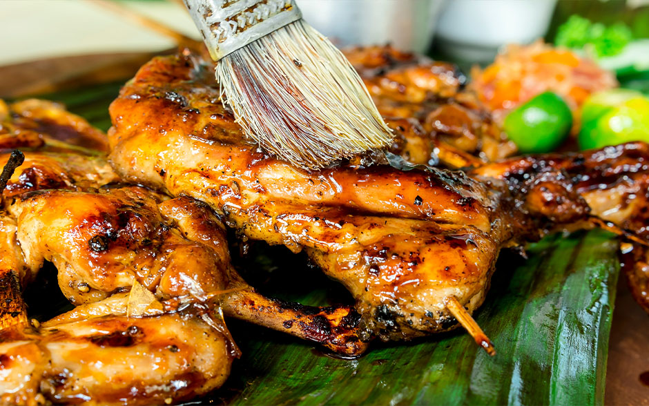 Close-up of chicken inasal with sauce.