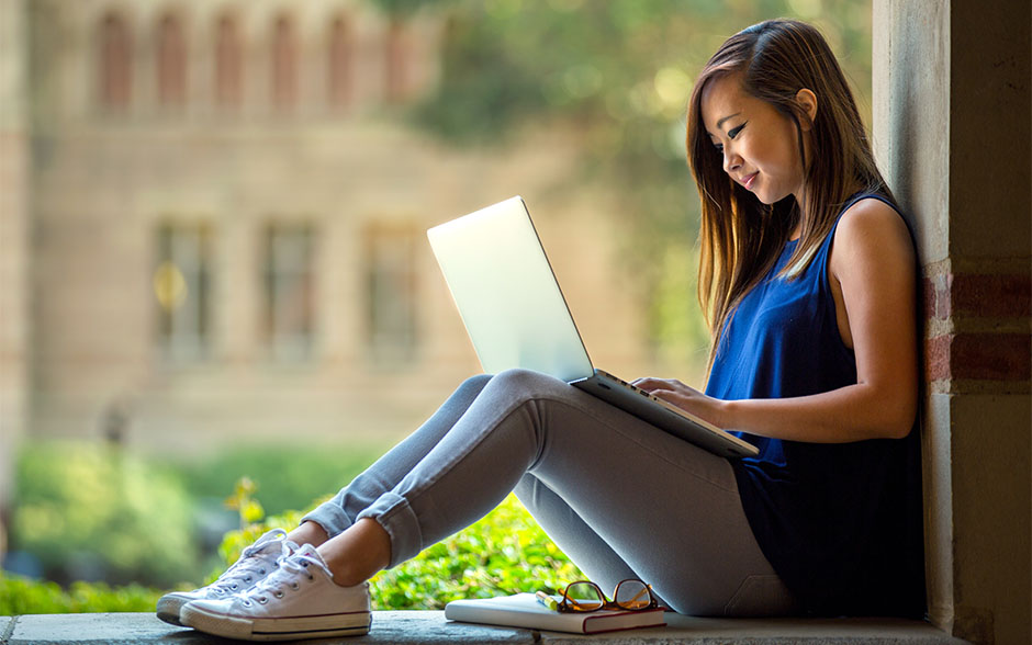 A female student using her laptop within the student campus