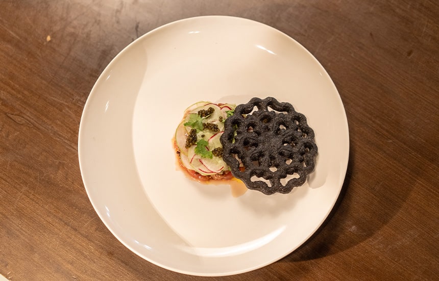 Chef Kevinâs squid ink buñuelo with local tuna and ossetra caviar.