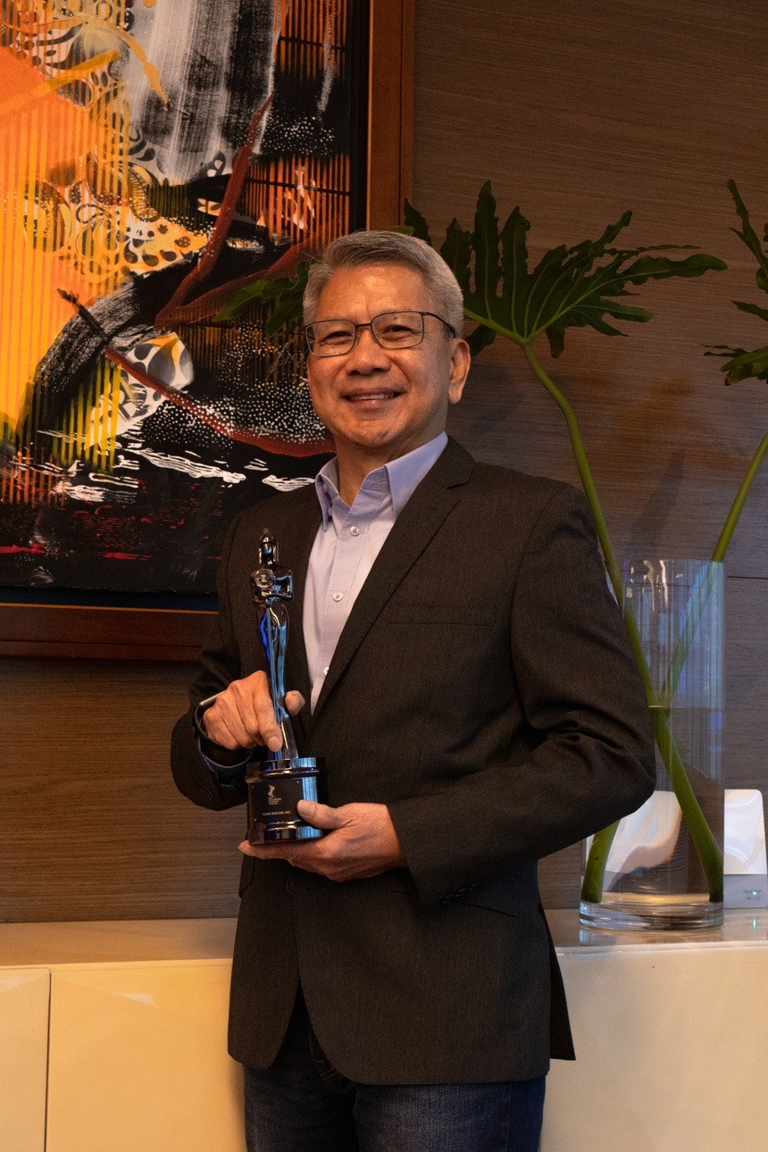 Globeâs Chief Human Resources Officer Renato Jiao, holding the HR Asia Best Companies to Work For trophy.