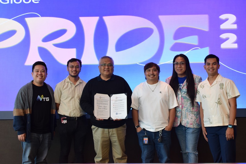 Globe President and CEO Carl Cruz, joined by Globe Pride ambassadors, showing a signed PFIP Pledge.
