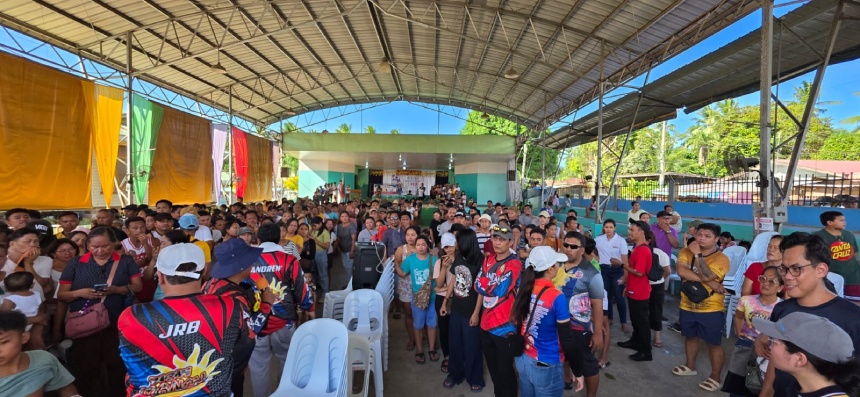 A large crowd gathered at a covered community court during relief operations.