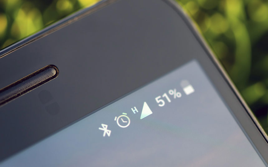 Close-up photo of phoneâs icons on the screen showing Bluetooth, alarm clock, network signal, and battery percentage.