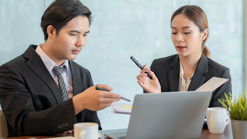 An Asian male and female collaborating at the office.