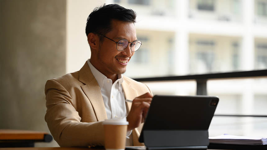 A male professional using his tablet for work at the office.
