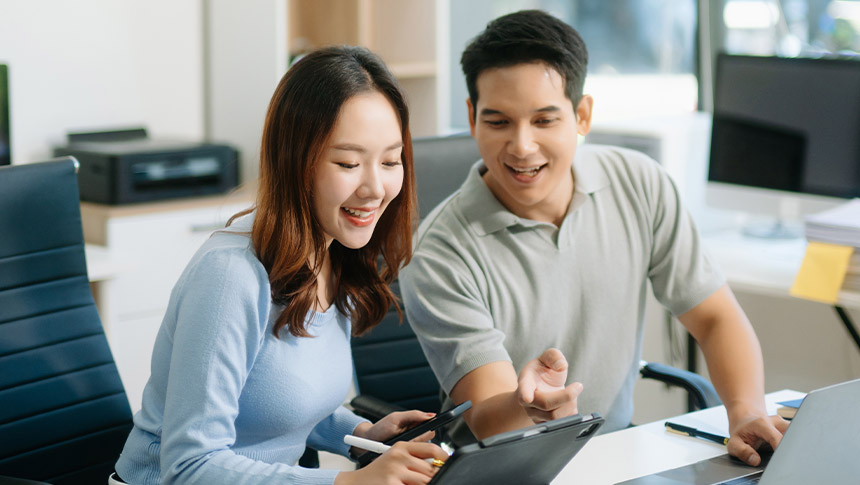 A male and female professional something on a tablet.