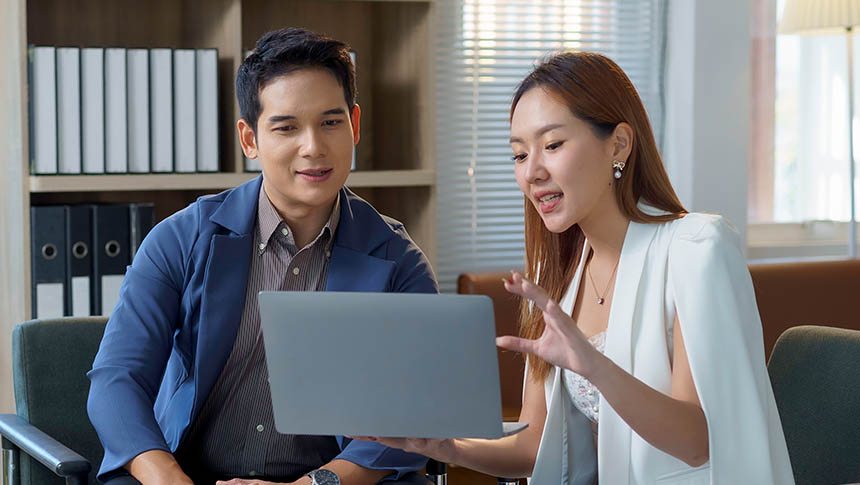A male and female professional discussing work.
