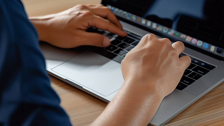 Hand of a male professional using a laptop for work.