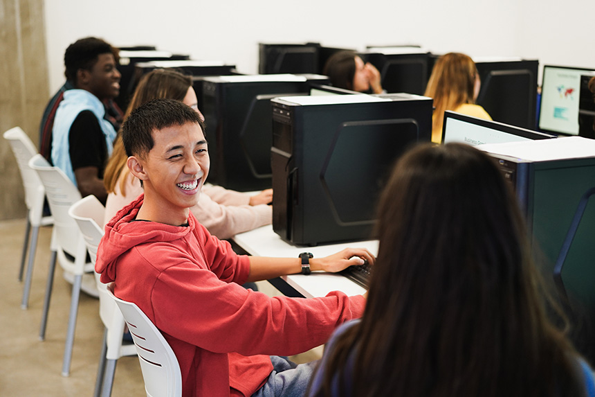 a young man in his office space, smiling at his co-intern