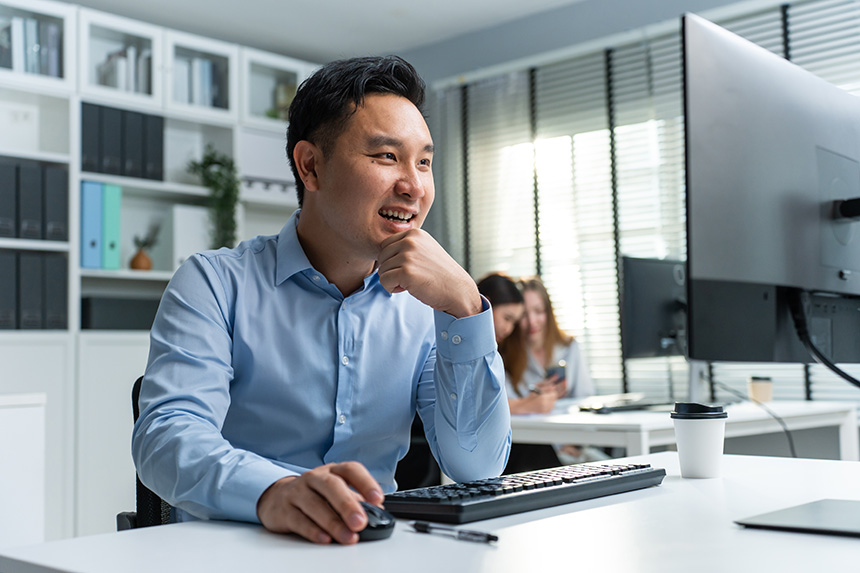 Asian man using computer researching requirements for MySSS card.