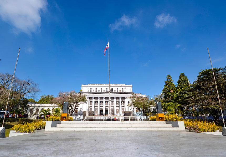 The Negros Occidental Provincial Capitol in Bacolod City, showcasing its neoclassical architecture and central flagpole on a bright day.