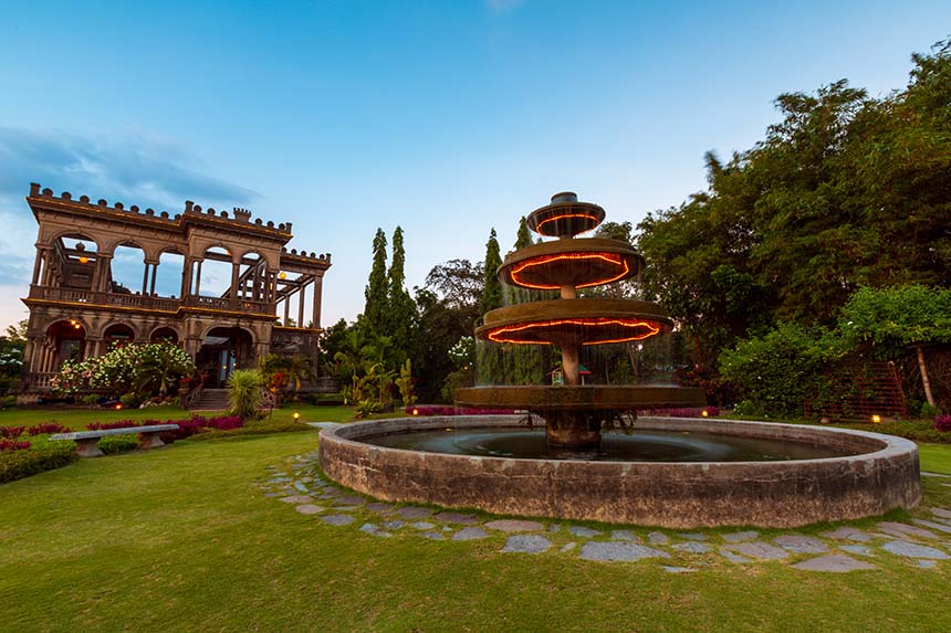 The Ruins in Talisay City, Negros Occidental, with its glowing fountain and historic mansion at dusk.