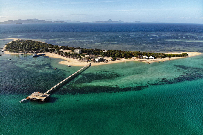 Aerial view of Lakawon Island in Negros Occidental showing its long wooden pier, white sand beach, and turquoise waters.
