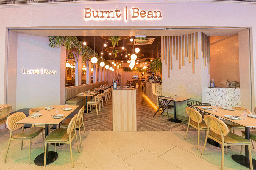 A warmly lit restaurant interior with modern seating, offering a pet-friendly dining space for pet owners.