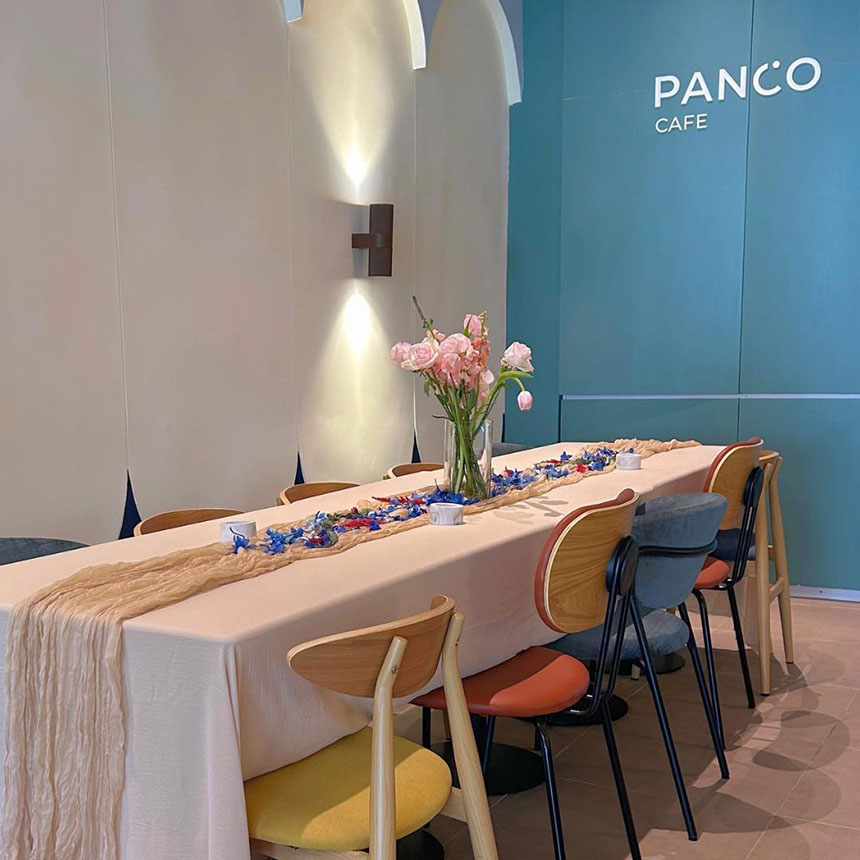 Cafe interior at Panco Makati with a long communal table, modern decor, and soft lighting.
