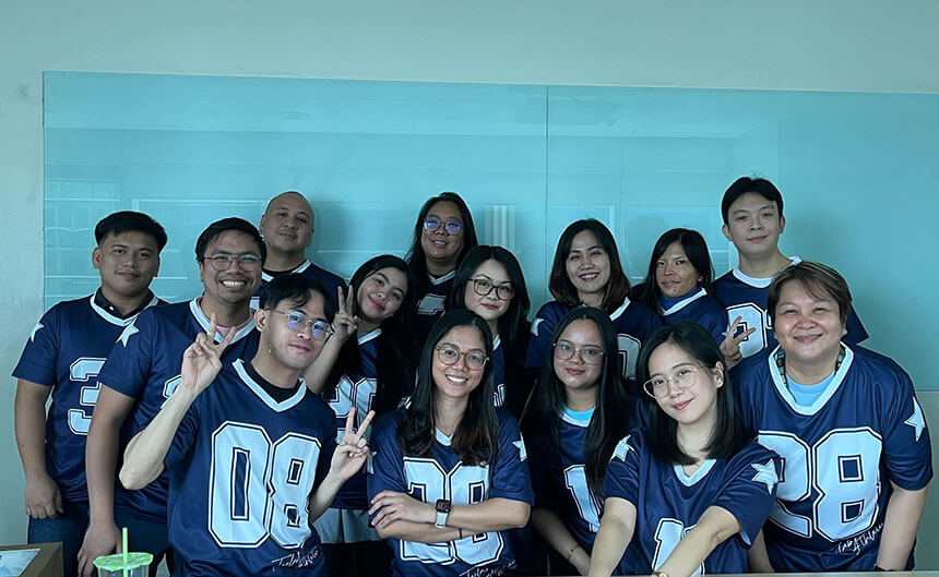 Globe Website Operations Team posing for a group photo in matching blue and white jerseys.