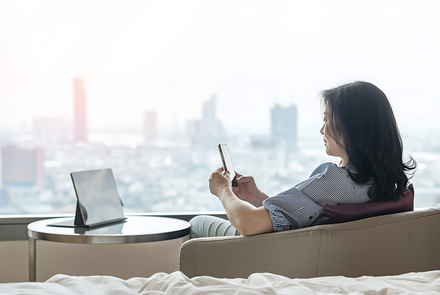 A woman relaxes in a comfortable seat near a large window