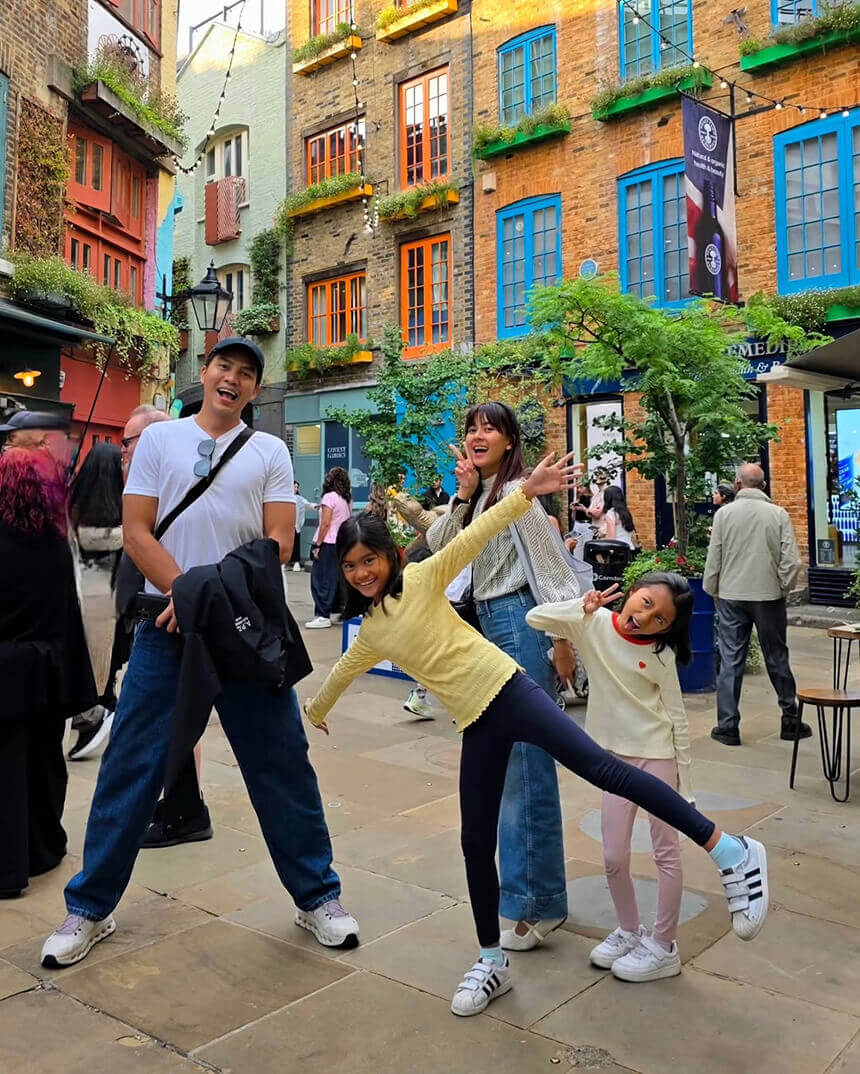 Bianca Gonzalez and her family posing playfully on a colorful city street during a trip to London.