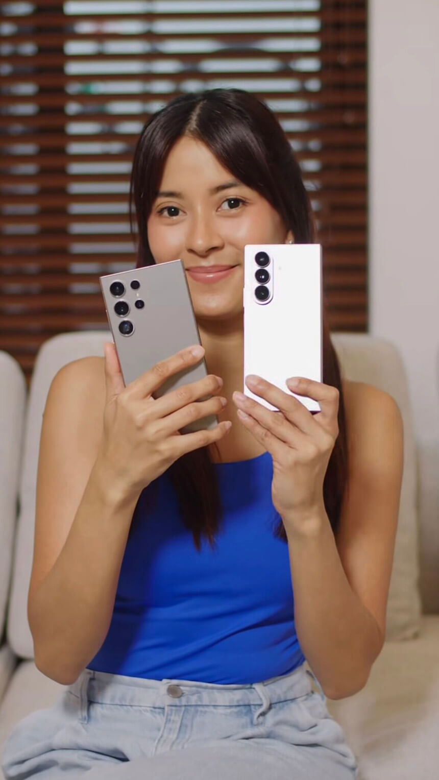Bianca Gonzalez smiling while holding two smartphones.