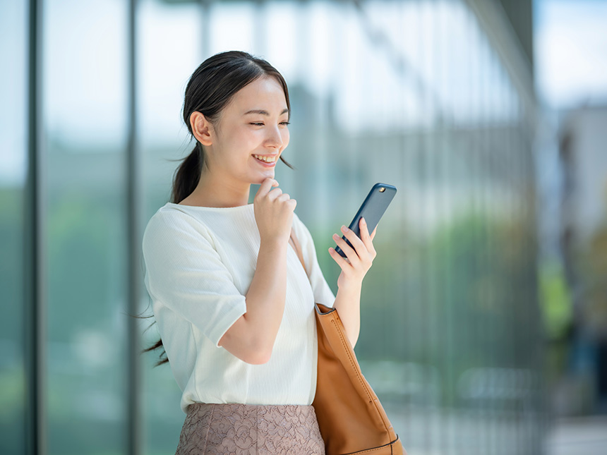 A woman engaged with her mobile phone, surrounded by urban scenery.
