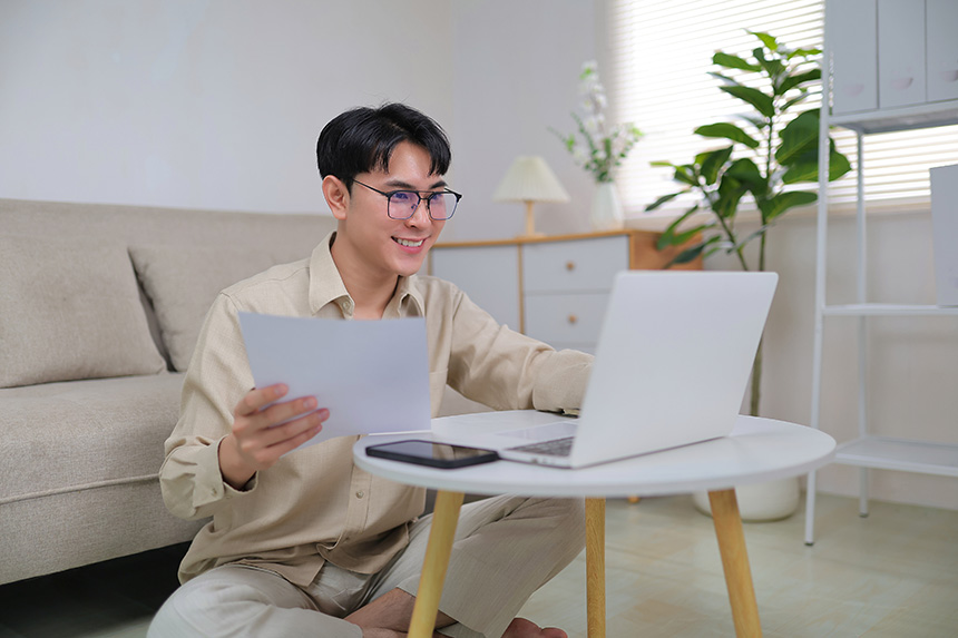Traveler reviewing documents and booking details on a laptop while preparing for an upcoming flight