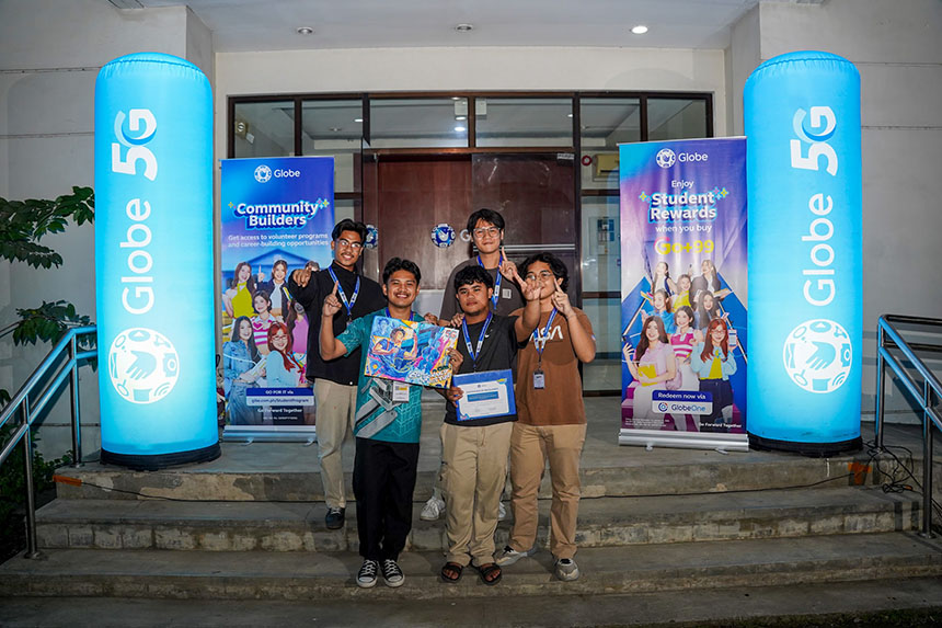 Gabriel Banas and his team pose in front of Globe's sign, showcasing a friendly atmosphere while holding their winning mural and certificate. 