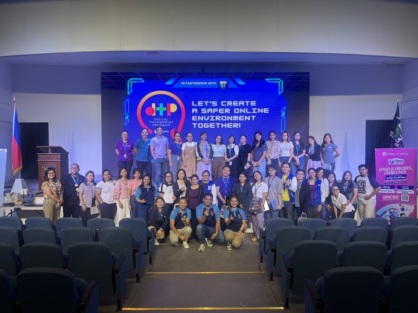 A group of students, educators, and Globe representatives posing on stage at a Globe Digital Thumbprint Program.