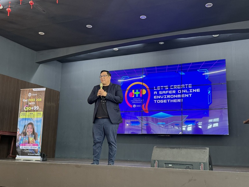 A Globe representative speaking on stage during a Digital Thumbprint Program.