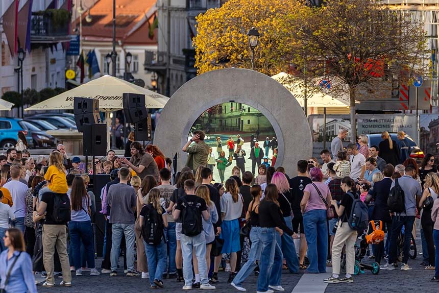 People gather around the original Portal installation in Vilnius, Lithuania, interacting with a live video link to another city.
