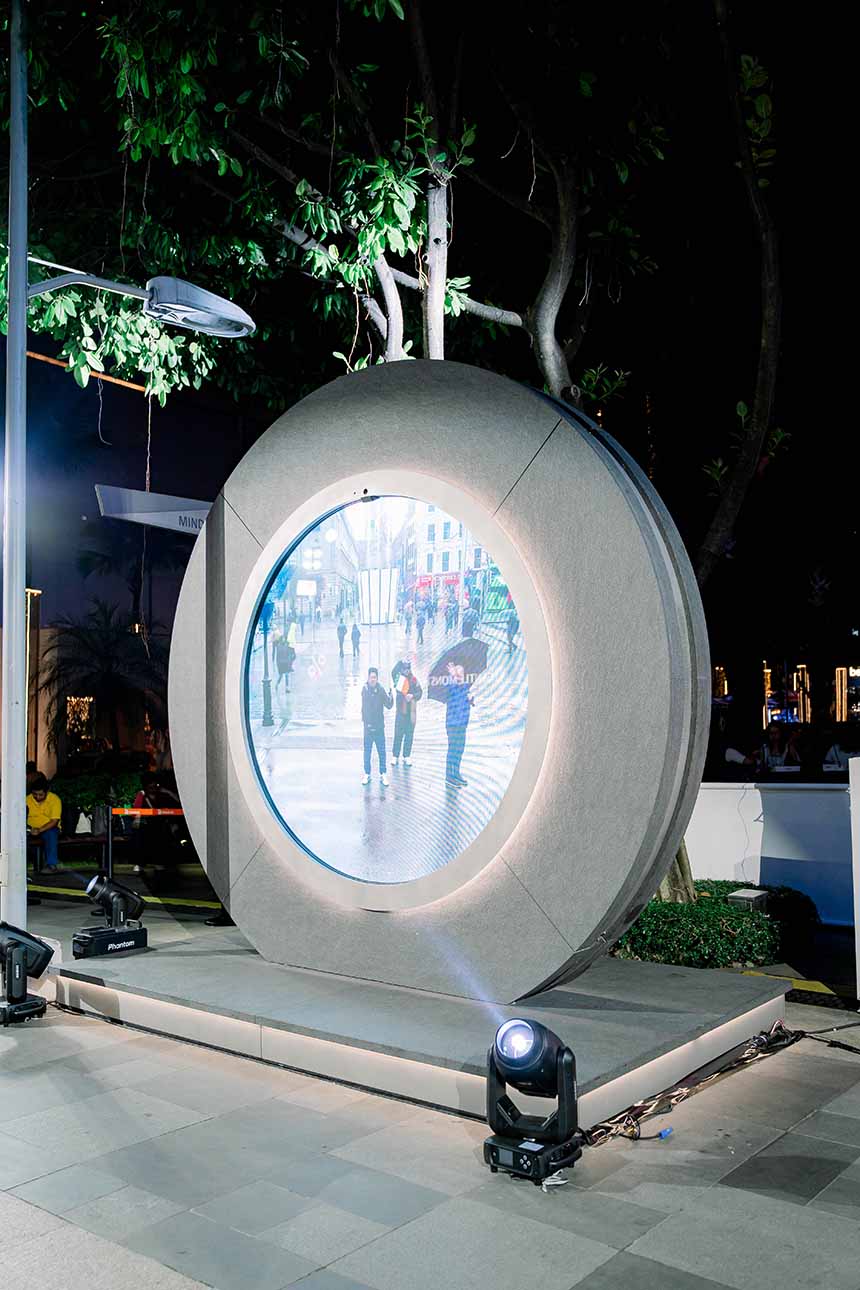 The circular Portal installation at Bonifacio High Street shows a live video feed connecting to another city during the evening.