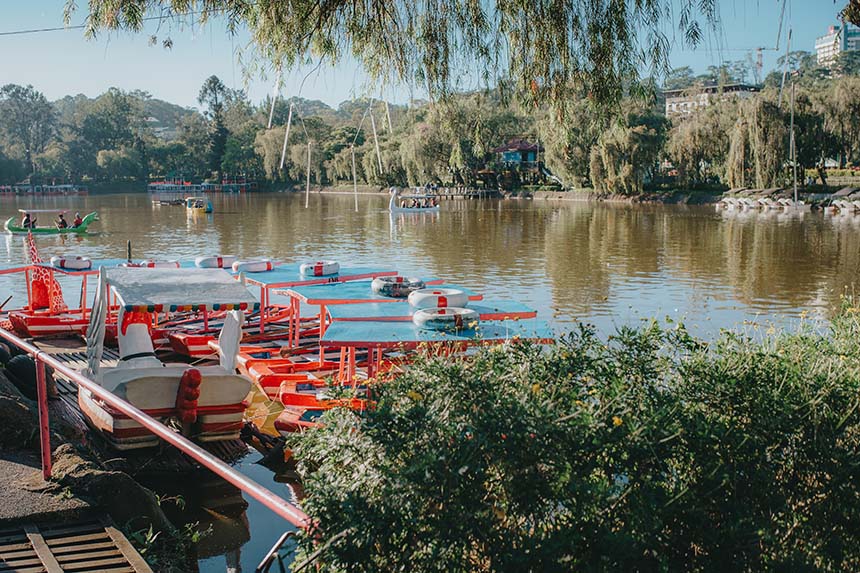 Paddle boats on Burnham Park lake surrounded by trees in Baguio.