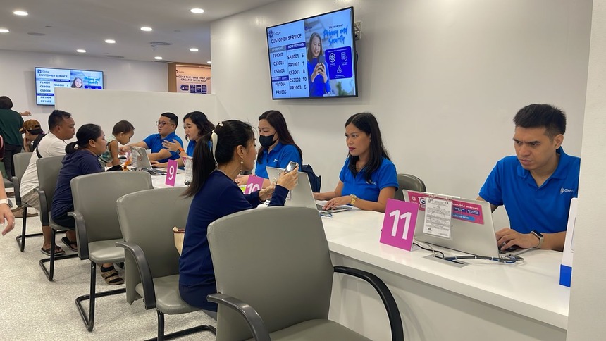 Globe Store staff assisting customers at service counters inside the store.