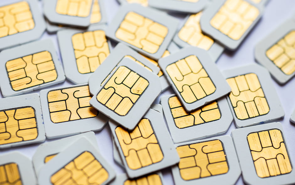 Close-up of a scattered pile of SIM cards, highlighting their gold contact points, representing communication and technology connectivity.