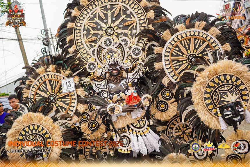 Ati-Atihan Festival participant in traditional costume with black face paint and elaborate tribal attire.