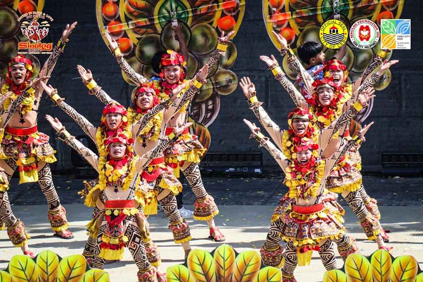 Sinulog Festival dancers in colorful costumes performing on stage in Cebu City.