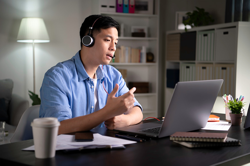 Man working from home on a laptop during an online meeting.