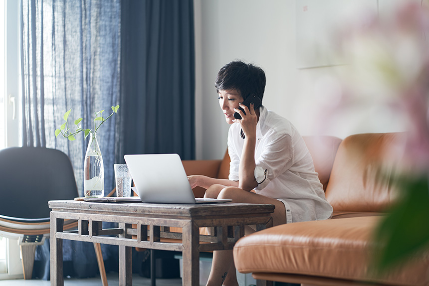 Woman on a video call at a desk with a laptop and a cup of coffee.